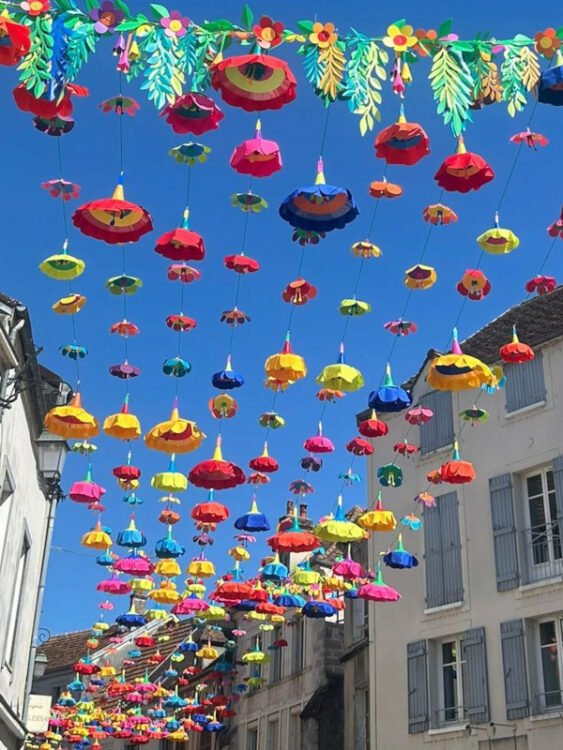 ciel de rue sous forme de fleurs multicolores de différentes tailles, élaboré par l'entreprise Toutcomme, spécialisée dans les décorations de rue. 